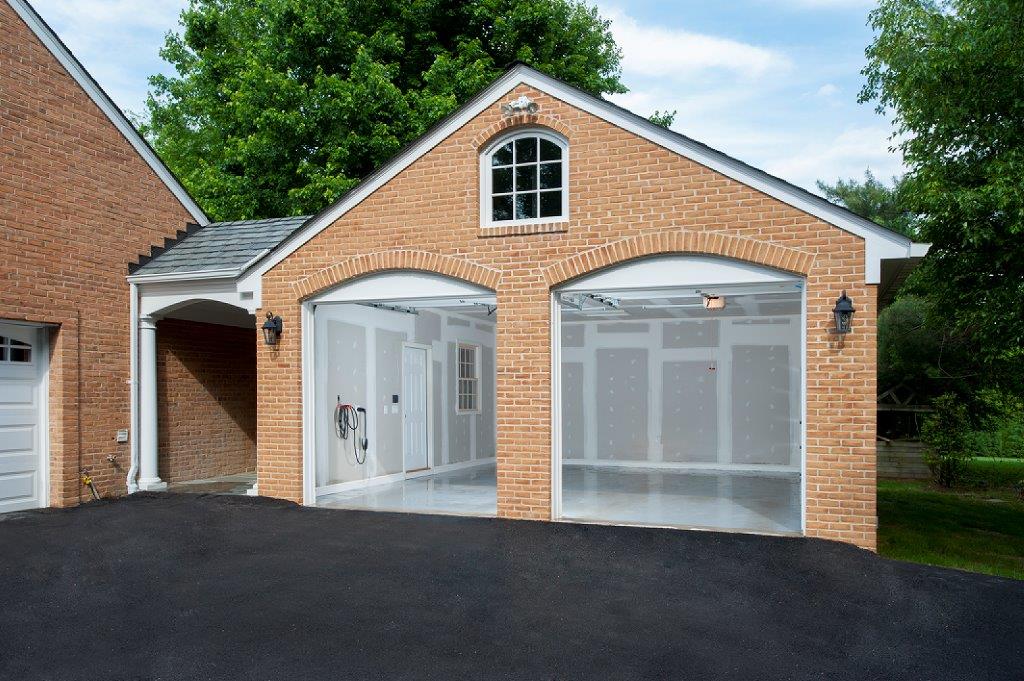 brick garage home addition with blut skies